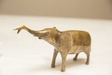 Vintage African elephant sculpture shown in profile with an aged golden patina.