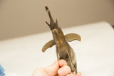 Upward view of the golden patina elephant's face, tusks, and raised trunk.