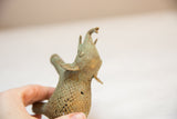 Textured mesh and green patina of a vintage African bronze elephant, held by hand.
