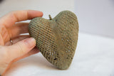 Close-up of vintage African bronze heart's intricate mesh design and green patina.