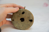 Handmade aged African bronze with textured concentric rings and irregular holes.