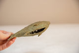 Angled view of a vintage African bronze fish showing its hollow body and textured wire design.