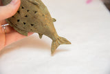The sculpted tail and body of the vintage bronze fish showing its oxidized wire texture.