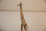 The handmade texture and light patina on the vintage bronze giraffe's head and neck.