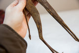 Detailed view of the handmade bronze giraffe's slender legs and textured light patina.