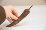 Handmade vintage African iron chili pepper showing its unique rustic texture.