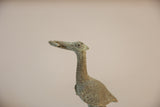 Profile close-up of the vintage bronze stork's head and neck showing oxidized texture.