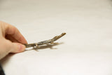 Hand holds vintage African black-backed crocodile sculpture, showing textured patina.