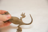 View of the vintage bronze gecko's hand-formed back legs and curved tail.