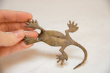 Underside view of a vintage bronze gecko showing its handmade, textured patina.