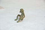 Side-back view of the handmade bronze sitting monkey with green patina.