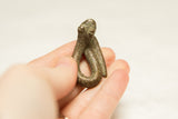 A small vintage African snake sculpture with textured stripes held in a hand.