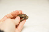 Small vintage African snake sculpture held in hand, showing its dark, aged patina.