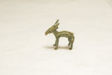 Vintage African impala sculpture showing textured surface and weathered green patina.