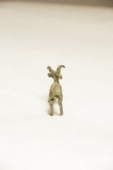 Rear view of a vintage African ram sculpture showing its dark oxidized patina.