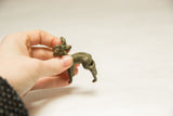 Vintage African ram sculpture held in hand to show its small scale and textured details.
