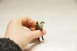 Vintage African ram sculpture held in hand, showing its petite scale and oxidized patina.
