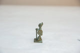 Side view of a vintage African warrior collectible with oxidized texture and shield detail.