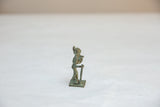 A side view of the small vintage warrior statuette highlighting its oxidized finish.