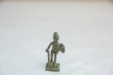 Vintage African warrior figurine with an oxidized green patina holding a staff and shield.