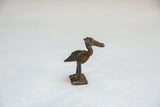 Side profile of the vintage African bird sculpture showing its textured body and tail.