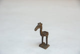 The crowned head and long beak of the vintage handmade African bird figure.