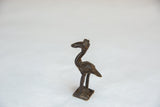 The handmade form and slender profile of the vintage crowned bird sculpture.