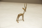 The elegant turning pose of a vintage African gazelle with a textured, light patina.
