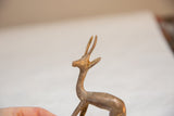 Textured horns and aged golden patina on the head of a vintage metal gazelle.