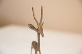 The handcrafted face and textured horns of a vintage African gazelle sculpture.