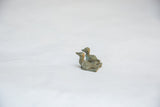 Detailed side view of two vintage bronze sitting birds with an aged, textured patina.