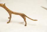 Textured light patina on the vintage bronze cheetah's midsection and tapering tail.