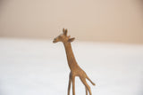 The speckled, aged bronze finish on the head and neck of a vintage giraffe.