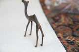 Rear angle of a vintage dark bronze camel highlighting its slender handmade form.