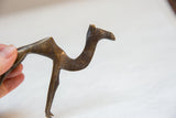 Side profile of a vintage African bronze camel showing its handmade details and dark patina.