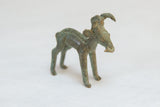 Side view of a vintage bronze ram highlighting its forward horn and rustic, patinated texture.