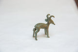 Angled view of the vintage bronze ram sculpture showing its rustic texture and slender form.