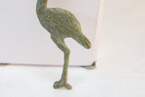 Side view of the vintage stork sculpture highlighting its oxidized green patina and slender leg.