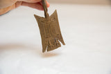 The rustic texture and hand-molded linear patterns on a vintage bronze medallion.