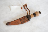 Vintage African dagger with rustic wooden handle and etched leather sheath.