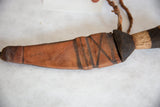 Vintage African dagger's handmade leather sheath with dark stripes and natural wood handle.