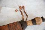 Vintage African dagger with a braided leather loop and wooden handle.