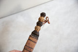 The carved cheetah-print wooden handle and top of the sheathed vintage dagger.
