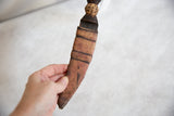 Vintage African dagger held to show the scale of its handmade sheath and cheetah handle.