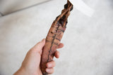 Handmade stitching and weathered texture on the vintage African dagger's sheath held in hand.