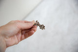 Vintage bronze lizard pendant held in hand, showing its small scale.