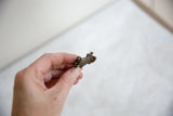 Vintage bronze turtle hatchling pendant showing its small scale and textured finish.