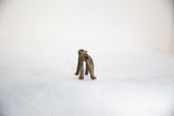 Rear view of a vintage African dark bronze monkey showing its smooth back and legs.