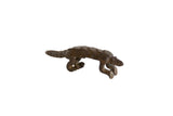 Vintage African dark bronze pangolin sculpture with a long curved tail and textured, segmented body.