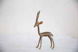 Profile view of a vintage African bronze gazelle showing its slender handmade form and light patina.